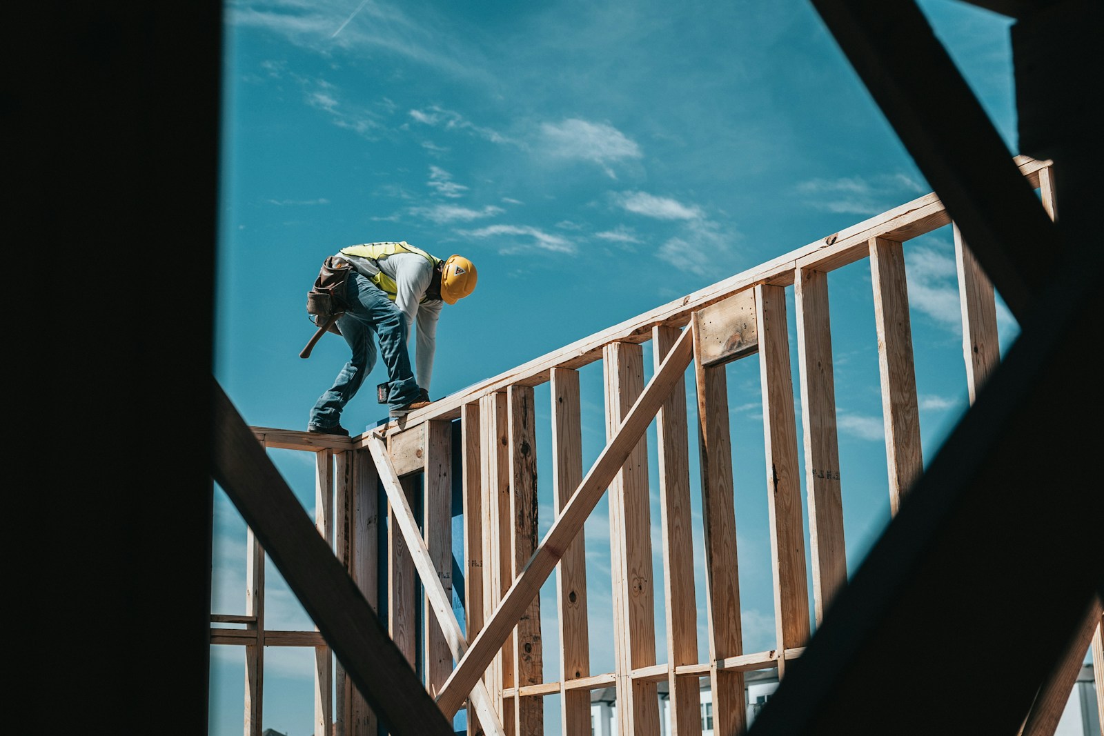 man in yellow shirt and blue denim jeans jumping on brown wooden railings under blue, workers compensation